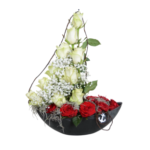 En blomsterarrangemang formad som en båt med vita rosor, brudslöja och röda rosor, dekorerad med ett ankare.